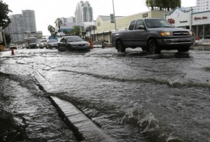 Vehicles negotiate heavily flooded streets as rain falls, Tuesday, Sept. 23, 2014, in Miami Beach, Fla. Certain neighborhoods regularly experience flooding during heavy rains and extreme high tides. CREDIT: AP Photo/Lynne Sladky