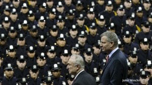 New York City Mayor Bill de Blasio, right, and NYPD police commissioner Bill Bratton, center, stand on stage during a New York Police Academy graduation ceremony at Madison Square Garden in New York. Mayor Bill de Blasio declares he has moved past the crisis with police that threatened to derail his administration. He says in an interview with The Associated Press that he was able to pull off the feat sticking to a strategy to maintain the moral high ground and avoid confrontation with police unions. At the same time, public opinion turned against police for their behavior in the feud, including turning their backs on the mayor. Credit: John Minchillo/AP