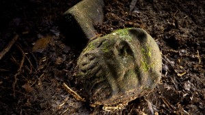 A “were-jaguar” effigy, likely representing a combination of a human and spirit animal, is part of a still-buried ceremonial seat, or metate, one of many artifacts discovered in a cache in ruins deep in the Honduran jungle. Credit: National Geographic/Dave Yoder