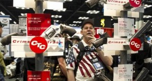 Convention goers check out handguns equipped with Crimson Trace laser sights at the 143rd NRA Annual Meetings and Exhibits at the Indiana Convention Center in Indianapolis, Indiana on April 25, 2014 Credit: Agence France-Presse