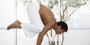 Man balancing body in yoga position, side view. Credit: Huffington Post