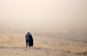 A couple hugs while standing on a hilly area overlooking Cairo on a dusty and hazy day where temperatures reached 114 Fahrenheit, May 27, 2015.  Credit: Reuters/Asmaa Waguih