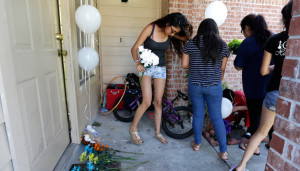 People place flowers and balloons at a house in Houston, Texas, on Aug. 9, 2015, where eight people were killed. Credit: Associated Press