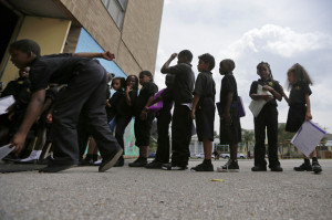 Students wait in line at ReNEW SciTech Academy, a charter school in New Orleans, Thursday, Aug. 14, 2014. Nine years after Hurricane Katrina, charter schools are the new reality of public education in New Orleans. The vast majority of public school students will be attending a charter school established by a state-run school district created in the wake of the storm. Credit: AP Photo/Gerald Herbert