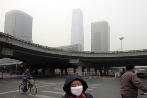 A pedestrian wearing a protective mask in Beijing, January 17, 2012. Decades of coal-powered industrialization combined with the government-promoted car craze have brought China the worst air pollution in the world.  Credit: Gilles Sabrie/The New York Times