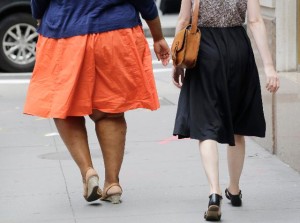 An obese woman, left, walks in New York, Monday, July 13, 2015. Credit: Mark Lennihan/AP