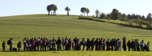 Migrants wait behind a police car during their way from the Austrian-German border to the first registration point of the German federal police in the small Bavarian village Wegscheid, southern Germany, on October 12, 2015. AFP PHOTO / CHRISTOF STACHE