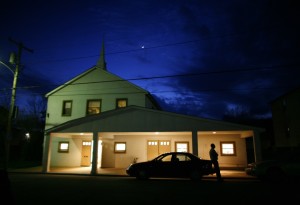 A man sits on his car outside the Riverview Baptist Church in Wellsburg, West Virginia April 6, 2011. The city is a part of America's Midwestern "Rust Belt", the heartland of the country and home to big unionized manufacturers like the auto and steel industries. Wellsburg, with a population of about 2,500, is located on the Ohio River in the northern panhandle of West Virginia. Credit: Reuters/Eric Thayer 