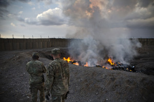 U.S. Army soldiers watch garbage burn in a burn-pit at Forward Operating Base Azzizulah in Maiwand District, Kandahar Province, Afghanistan, February 4, 2013. Credit: Reuters/Andrew Burton 