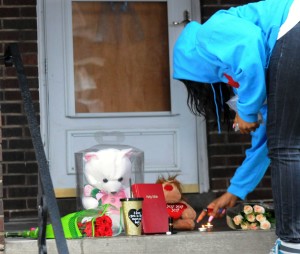 Gazette A mourner leaves candles at a makeshilft memorial on the steps of the scene of the shooting. Credit: John Heller/Posst-Gazette