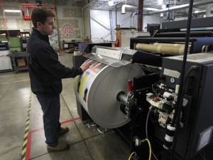 Digital press operator Steve Foster at Mercury Printing in Rochester, N.Y., feels for wrinkles in the paper on the company's Kodak Prosper 5000XL injet press. Kodak is pinning its hopes for recovery from bankruptcy on digital printing. Credit: ANNETTE LEIN, GANNETT)