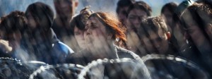 A woman screams as migrants and refugees demonstrate behind a fence and barbed wire at the Greece-Macedonia border, near Gevgelija on March 2, 2016. Macedonia on March 2, allowed some 170 refugees to cross its border with Greece as 10,000 more were left waiting at the border under miserable conditions. / Credit: AFP / DIMITAR DILKOFF