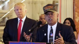  Republican presidential candidate Donald Trump listens at left as Al Baldasaro, a New Hampshire state representative, speaks.