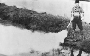 Council worker dusting DDT on mosquito breeding water by using a hand operated machine in Brisbane, 1949.