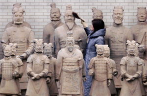  A Chinese shopkeeper dusts a statue of China's first Emperor Qin Shi Huang at a souvenir shop in Xian. Making replicas of the Terracotta Warriors and the emperor is a lucrative industry for people living on the harsh and barren plains of Shanxi province, where 26 years ago, Chinese farmer Yang Zhifa accidentally unearthed three of the 7,000 life-sized Terracotta Warriors guarding the tomb of China's first emperor. Although his discovery kicked off one of the greatest archaeological digs in history, local officials awarded him 10 yuan (US $1.20) for each of the three 2,200-year-old statues in 1974. Today, 1.5 million tourists a year visit Xian, a grimy industrial city that once vied with ancient Rome and Constantinople as the greatest metropolis on earth. Credit: Andrew Wong/Reuters