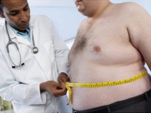 General practitioner measuring waist of obese patient 