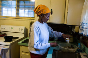 Sheila Cunningham rinses fish with bottled water in Flint, Michigan, October 6, 2016. Flint residents' fears over using the water have scarcely subsided, even as lead pipes are slowly being replaced.  Credit: Brittany Greeson / The New York Times