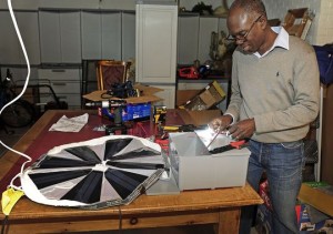 Mawuli Tse works on a portable solar unit at his workshop in Nashville. Credit: Jae S. Lee / The Tennessean)